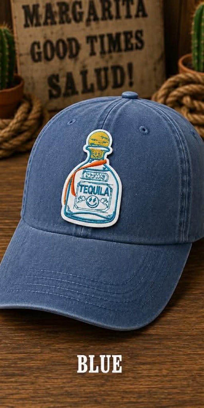 K&ouml;nnte beinhalten: Blaue Baseballkappe mit einem Tequila-Flaschen-Patch. Der Patch zeigt eine wei&szlig;e Flasche mit dem Wort "TEQUILA" und gelben und orangen Details. Das Wort "BLUE" befindet sich unten.