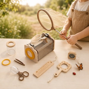Op de afbeelding: Een verzameling houten insectenonderzoeksspeelgoed, waaronder een net, een insectenbox, een vergrootglas en een liniaal. De set bevat ook een kleine pot, een pincet, een schaar en een kompas. Een kleine oranje vlinder en een rode lieveheersbeestje zijn ook aanwezig.