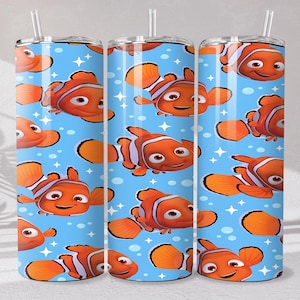 Puede incluir: Tres vasos de acero inoxidable con un patrón repetido de peces payaso naranjas y blancos sobre un fondo azul claro. Cada vaso tiene una pajita blanca. El diseño incluye estrellas y burbujas blancas.