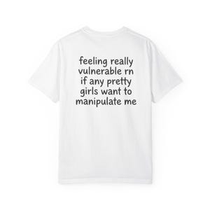 May include: White t-shirt with black text that reads "feeling really vulnerable rn if any pretty girls want to manipulate me". The shirt is a basic crew neck style.