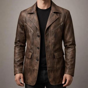 Könnte beinhalten: Braune Lederjacke im Blazer-Stil. Sie hat einen Reverskragen, zwei Brusttaschen mit Reißverschluss, zwei Vordertaschen und Knopfverschlüsse. Die Jacke hat ein Used-Finish für einen Vintage-Look.