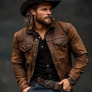 May include: A brown leather jacket with two chest pockets and button fastenings. The jacket is worn over a black shirt and paired with a brown belt with a decorative buckle. The person is also wearing a black cowboy hat and a watch.