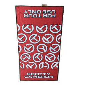 May include: Red golf towel with white circular logo pattern and the text "FOR TOUR USE ONLY" and "SCOTTY CAMERON" in white. The towel has a black border and a loop at the top for hanging.