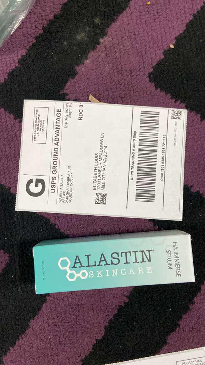 K&ouml;nnte beinhalten: Eine t&uuml;rkisfarbene Schachtel mit Alastin Skincare HA Immerse Serum neben einem USPS Ground Advantage Versandetikett. Das Versandetikett enth&auml;lt die Adresse des Empf&auml;ngers und Tracking-Informationen. Die Serumbox hat das Alastin Skincare Logo und Produktnamen.