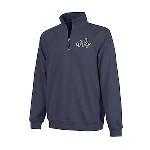 May include: Navy blue quarter-zip sweatshirt with a stand-up collar and a small embroidered design on the chest. The sweatshirt features a zipper closure and long sleeves. The embroidered design appears to be the letters "arb" in a cursive font.