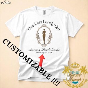 May include: White t-shirt with the text "One Less Lonely Girl" and "Anna's Bachelorette February 25.2026". The shirt features a brown silhouette inside an ornate frame. The word "CUSTOMIZABLE" is printed on the shirt.