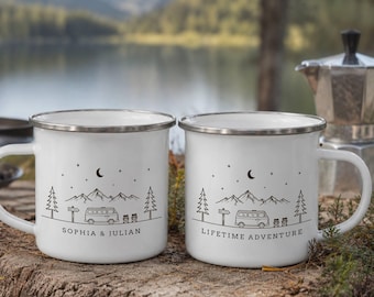 May include: Two white enamel mugs with silver rims, each featuring a black line art illustration of a camper van, pine trees, mountains, and a crescent moon. One mug is personalized with the text "SOPHIA & JULIAN" and the other with "LIFETIME ADVENTURE".