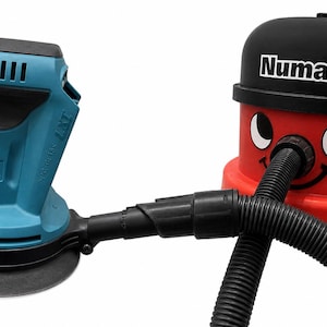 May include: A teal and black Makita sander connected to a red Numatic vacuum cleaner with a black hose. The vacuum has a smiling face and the word "Numatic" on top.