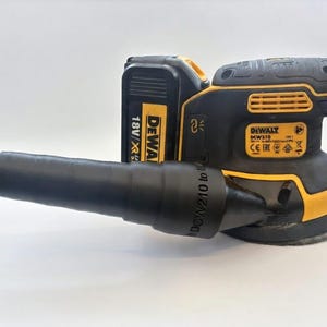 May include: A black and yellow DeWalt DCW210 random orbit sander with a black dust collection port. The sander has a battery pack attached and is set against a white background. The sander is designed for woodworking and other sanding tasks.