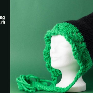 May include: A black and green knitted hat with a pointed tip and a long green cord. The hat is on a white mannequin head.