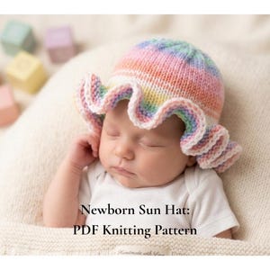 May include: A newborn baby wearing a colorful, knitted sun hat with a ruffled brim. The hat features pastel rainbow colors. The text "Newborn Sun Hat: PDF Knitting Pattern" is visible.