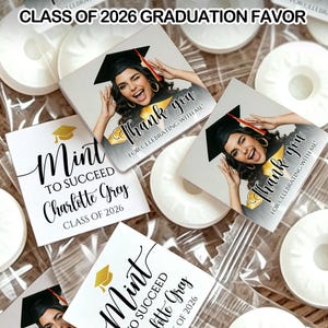 May include: Graduation favors featuring white mints and personalized cards. The cards have a photo of a graduate, the words "Thank You," and "Mint to Succeed." The text "Class of 2026" is also visible.