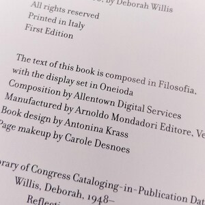 Puede incluir: Primer plano de una p&aacute;gina de libro con texto. El texto incluye informaci&oacute;n de derechos de autor, el nombre del autor y detalles sobre la producci&oacute;n del libro, como la imprenta y la fuente utilizada. El libro se titula "Reflections in Black".