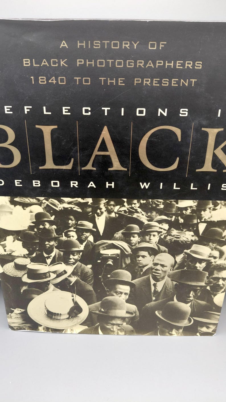 Puede incluir: Portada de libro con el t&iacute;tulo "A History of Black Photographers 1840 to the Present". La portada presenta una fotograf&iacute;a en blanco y negro de una multitud de personas, muchas con sombreros. Tambi&eacute;n es visible el nombre de la autora, Deborah Willis.