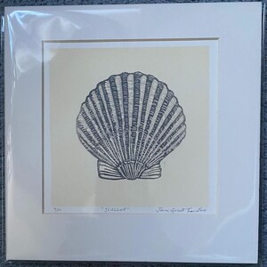May include: A black and white print of a scallop shell on a cream background. The print is framed and has the text "Scallop" and "Jane Greatorex" written below the image.