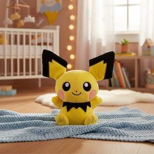 May include: A plush yellow Pikachu toy with black-tipped ears, pink cheeks, and a black zig-zag collar. The stuffed animal is sitting on a light blue knitted blanket. The background includes a crib and a shelf with books.