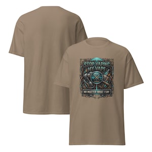 May include: A tan t-shirt with a graphic that reads "STOP VAPING MY VAPE" in a stylized font. The graphic includes a vape pen, a compass, and other mechanical elements. The phrase "NO MATTER WHAT I SAY" is below the main text.