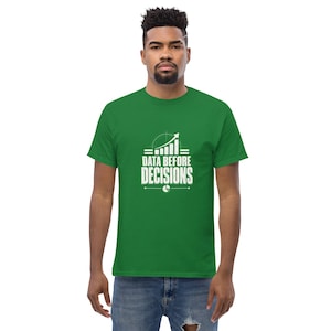 May include: A kelly green short-sleeved t-shirt featuring a white graphic print on the chest. The design includes a bar chart with an upward-trending arrow, a pie chart icon, and the text "DATA BEFORE DECISIONS" in a bold, sans-serif font.