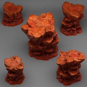 Könnte beinhalten: Fünf rötlich-orangefarbene, geschichtete Felsformationen unterschiedlicher Größe werden vor einem grauen Hintergrund dargestellt. Die Felsen haben eine raue, strukturierte Oberfläche mit kleinen, unregelmäßigen Formen und einigen kleinen, runden Details. Die Beleuchtung erzeugt Glanzlichter und Schatten.