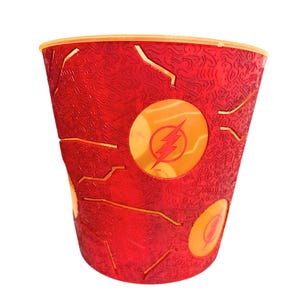 May include: A red plastic cup featuring a textured surface with raised lightning bolt patterns and two circular orange emblems. Each emblem displays a red lightning bolt symbol, which is the official logo of The Flash, complete with a small TM mark.
