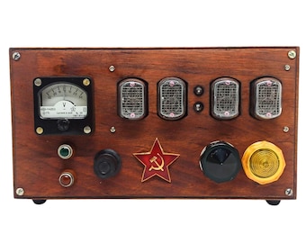 May include: A vintage-style wooden device with a voltmeter, digital display, and various knobs. It features a red star emblem and a retro aesthetic, likely a clock or measuring instrument.