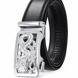 Puede incluir: Un cinturón negro con superficie texturizada y una hebilla rectangular de metal plateado que presenta un intrincado diseño de dragón en relieve. El mecanismo de la hebilla incluye una palanca lateral y una cremallera interna.
