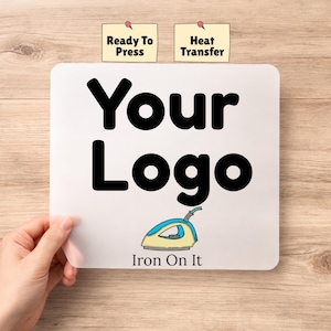 May include: A white square with the words "Your Logo" in bold black letters. Below the text is an illustration of an iron with the words "Iron On It". Two small yellow sticky notes above the square read "Ready To Press" and "Heat Transfer".