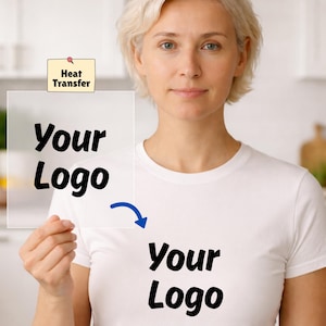 May include: A white t-shirt with the text "Your Logo" printed in black. A transparent sheet with the words "Your Logo" is held up next to the shirt, with a blue arrow pointing to the shirt. A small yellow sticky note with the words "Heat Transfer" is pinned to the transparent sheet.