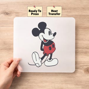 May include: A white heat transfer sheet with a classic Mickey Mouse design in black, red, and white. The sheet has the text "Ready To Press" and "Heat Transfer" on small yellow sticky notes.