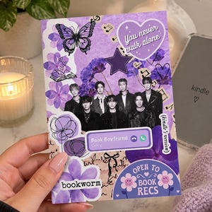 May include: A rectangular purple collage card featuring a group of seven individuals in black attire, a butterfly, a heart with the text You never walk alone, a phone interface reading Book Boyfriend, and text labels reading bookworm and Open to Book Recs.
