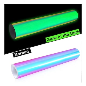 May include: A cylindrical roll of adhesive vinyl film shown in two states. The top roll glows with a bright green light against a black background labeled Glow in the Dark. The bottom roll displays a smooth iridescent finish labeled Normal.