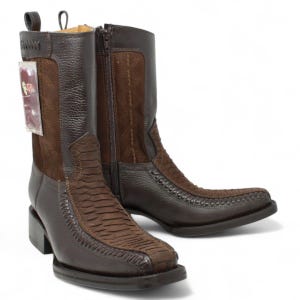 May include: Brown leather cowboy boots with a square toe and a zipper closure. The boots feature a textured design on the vamp and shaft, with a contrasting suede panel. The heel is a stacked block style.