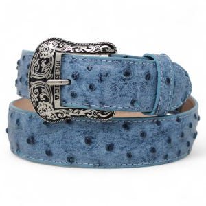 May include: A light blue belt with a textured pattern and a silver-colored buckle. The buckle has an ornate design and the word "TAINER" is visible. The belt is a medium width and has a matching light blue stitching.