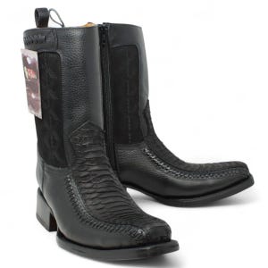 May include: Black leather cowboy boots with a square toe and a side zipper. The boots feature textured panels and decorative stitching. A small tag is attached to the left boot. The boots have a stacked heel.