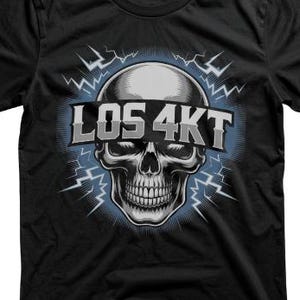 Peut inclure: T-shirt noir avec un motif de crâne détaillé et le texte "LOS 4KT". Le design comprend un motif d'éclairs bleus et blancs rayonnant derrière le crâne. Le t-shirt est en matière souple.