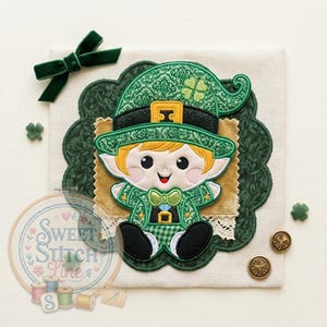 May include: A whimsical St. Patrick's Day themed applique featuring a smiling leprechaun in a green outfit and hat with a gold buckle. The design includes a green bow, shamrock buttons, and the text "Sweet Stitch Line" in a circular embroidery hoop.