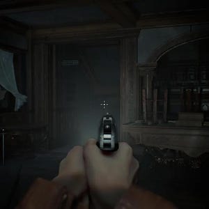 May include: A first-person perspective of a silver handgun held in two hands, aimed forward in a dimly lit, shadowed room with wooden architectural details. A small white crosshair is visible in the center, and a gun icon with 9/0 text is in the corner.