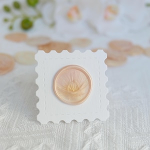 May include: A white ceramic mug with a black handle and the text "But First, Coffee" in a black, handwritten-style font. The mug is on a white surface.