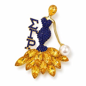 May include: A gold-toned brooch shaped like a figure wearing a blue crystal-encrusted bodice and a yellow crystal skirt. The figure holds a white pearl-like bead and stands next to the Greek letters Sigma Gamma Rho in blue crystals.