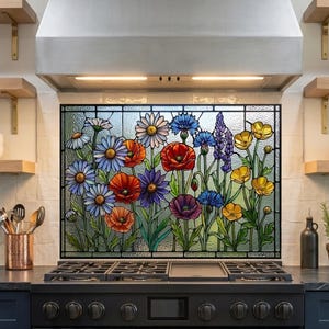 May include: A rectangular stained glass panel featuring a vibrant floral design with red poppies, blue cornflowers, yellow buttercups, and white daisies. The artwork is framed in black metal and displays a variety of colorful wildflowers with green stems.