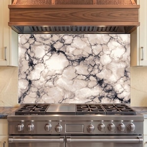 May include: A marble-patterned backsplash installed behind a stainless steel gas range. The backsplash features a white background with dark gray veining, creating a natural stone appearance. The range has six burners and a stainless steel finish.