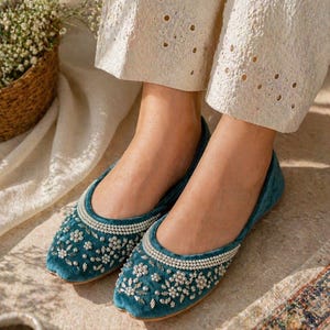 May include: Teal velvet flats with detailed floral beadwork and a pearl trim. These stylish shoes have a rounded toe. Ideal for special events or daily wear. The design is both elegant and comfortable.
