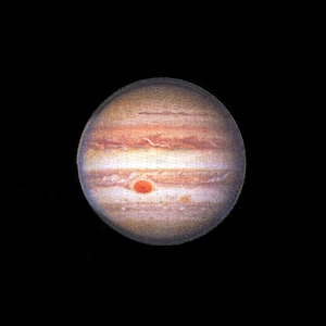 May include: A white ceramic mug with a black handle and the text "But First, Coffee" in a bold, black font. The mug is filled with a dark liquid, likely coffee, and sits on a light-colored surface.