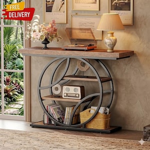 May include: A brown and black console table with a circular metal frame and wooden shelves. The table features a wooden top, a vintage radio, and a lamp. The image also includes a record player and a vase of flowers.