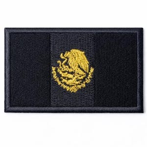 May include: A rectangular black patch featuring the Mexican coat of arms in gold embroidery. The emblem is centered on a vertical stripe, with the flag's design on a white background.