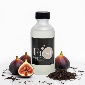 May include: A frosted glass bottle with a black cap and a label reading First Impression SCENTS, surrounded by three whole purple figs, one halved fig showing red interior seeds, and a small pile of dark brown dried tea leaves.
