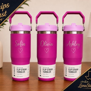 May include: Three personalized magenta Stanley Iceflow Flip Straw Tumblers. Each tumbler has a name and heart graphic. The tumblers have a pink handle and lid. The text "THE ICEFLOW FLIP STRAW TUMBLER" is printed on the label.