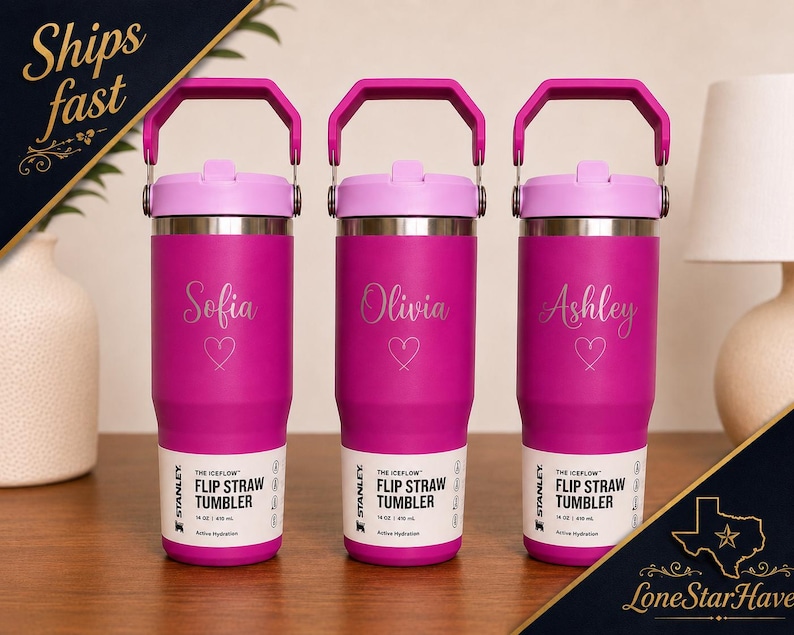 May include: Three personalized magenta Stanley Iceflow Flip Straw Tumblers. Each tumbler has a name and heart graphic. The tumblers have a pink handle and lid. The text "THE ICEFLOW FLIP STRAW TUMBLER" is printed on the label.