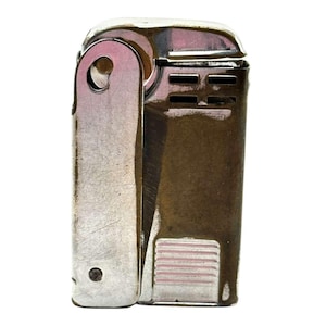 May include: A rectangular metal lighter with a polished silver finish. The device features a hinged side panel, a series of horizontal ventilation slots near the top, and a textured rectangular button at the base for ignition.