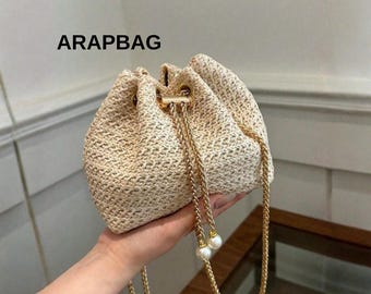 Sac seau tissé évidé pour femme Mini sac à bandoulière en paille avec cordon de serrage chaîne épaule plage sac à main d'été